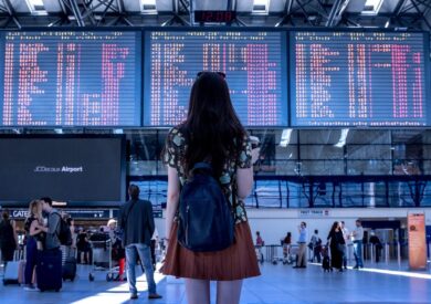 Putnica na aerodromu gleda tablu sa polascima letova